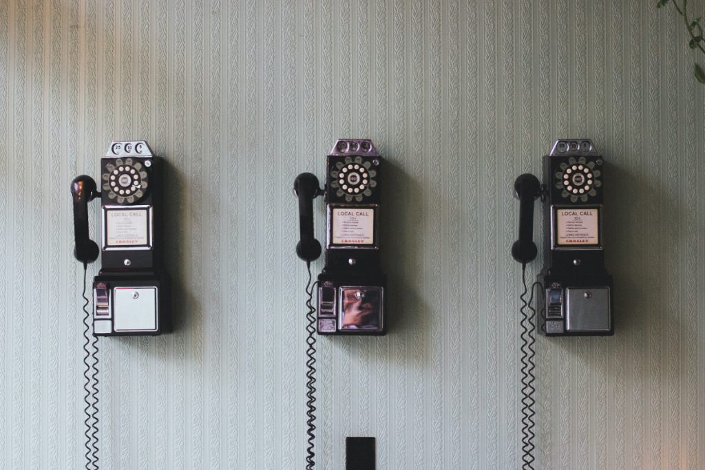 Three phones on a wall symbolize how the way we communicate is changing