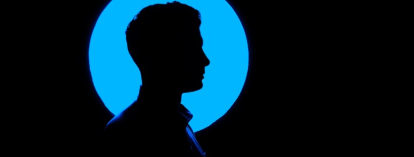 A blue circle on a black background shows the silhouette of a man's head.